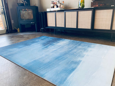 Dark blue light blue white yoga and exercise rug next to end table in home